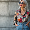 A stylish woman over 50 wearing high-waisted straight-leg jeans and a fitted blouse.